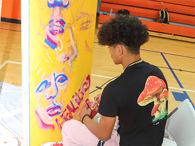A young activist in Newark paints a mural.